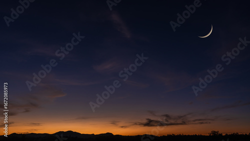 Crescent moon on dusk sky background, Twilight sky clouds over landscape mountain in summer evening, Religion of Islamic and free space text Ramadan Kareem, Eid Al Fitr, Eid Al Adha, Eid Mubarak