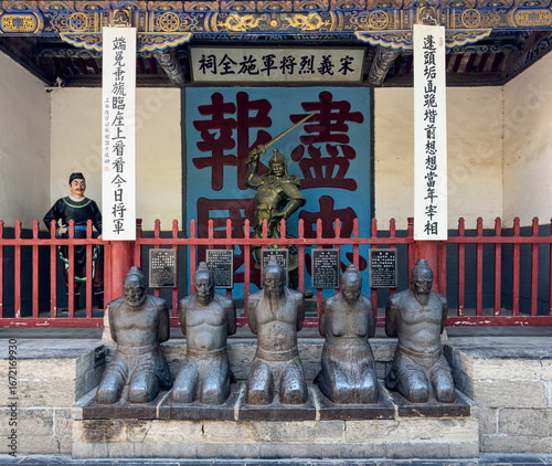 Kneeling statues of traitorous officials, their accomplices at Shi Quan Shrine with Shi Quan holding sward in historical Yue Fei Temple, Tangyin, Anyang, Henan, China. Heritage.