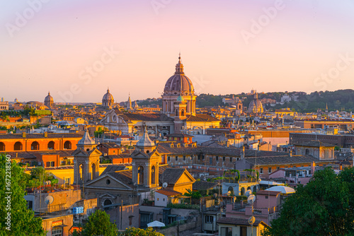 Sunset light over the rooftops and domes of historic Rome, Italy, captured from above.