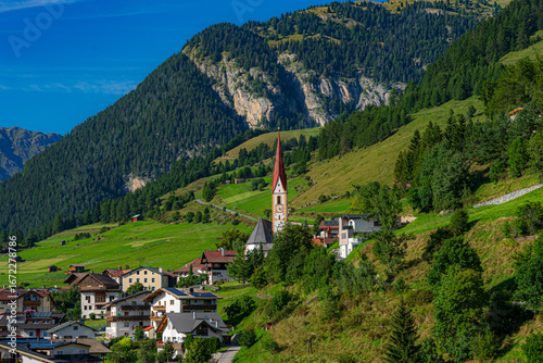 Alpenszenerie. Blick auf die Kirche von Nauders vor Bergkulisse (Österreich, Tirol)