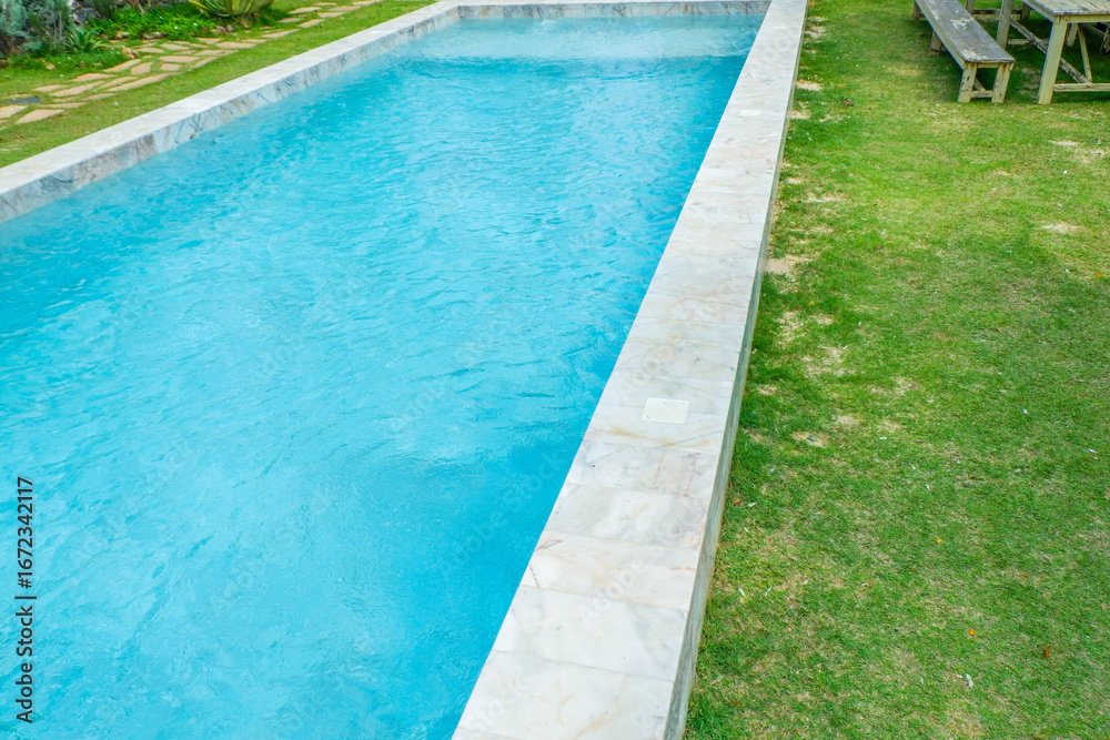 Obraz premium Empty swimming pool with sunbed and white umbrella in resort hotel for vacation leisure and white sand,resort neary sea and beach in summer.