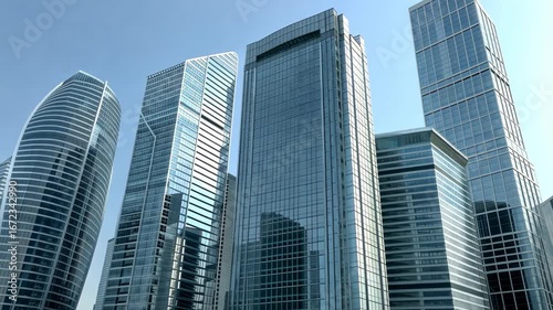 Wallpaper Mural Tall glass buildings demonstrate cutting-edge architecture and urban development against a clear blue sky in this bustling area Torontodigital.ca