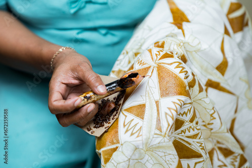 Indonesian woman Creating Traditional Batik Patterns in workshop