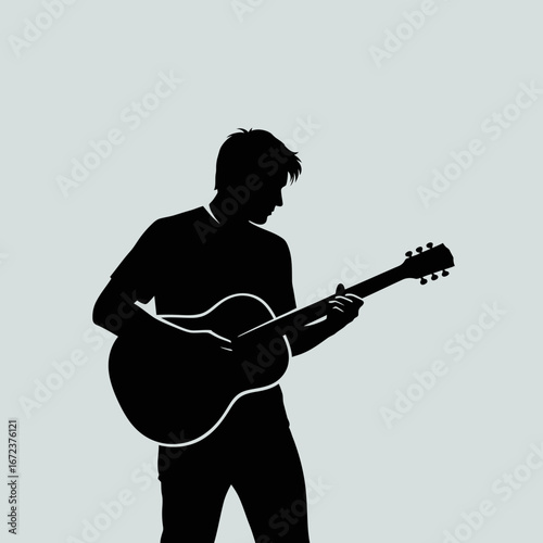 Silhouette of a person playing an acoustic guitar.