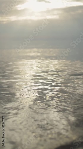 The calm water ripples elegantly reflect the soft, gentle light of a cloudy sky, creating a truly tranquil atmosphere