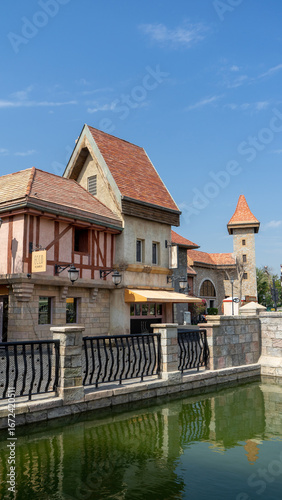 Walking area with shops and restaurants in United Arab Emirates. Riverland, Dubai. Houses in style of medieval Europe. Vertical image