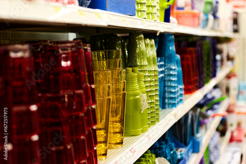 Colorful Plastic Cups and Bottles Arranged Neatly on Supermarket Shelf for Home Organization