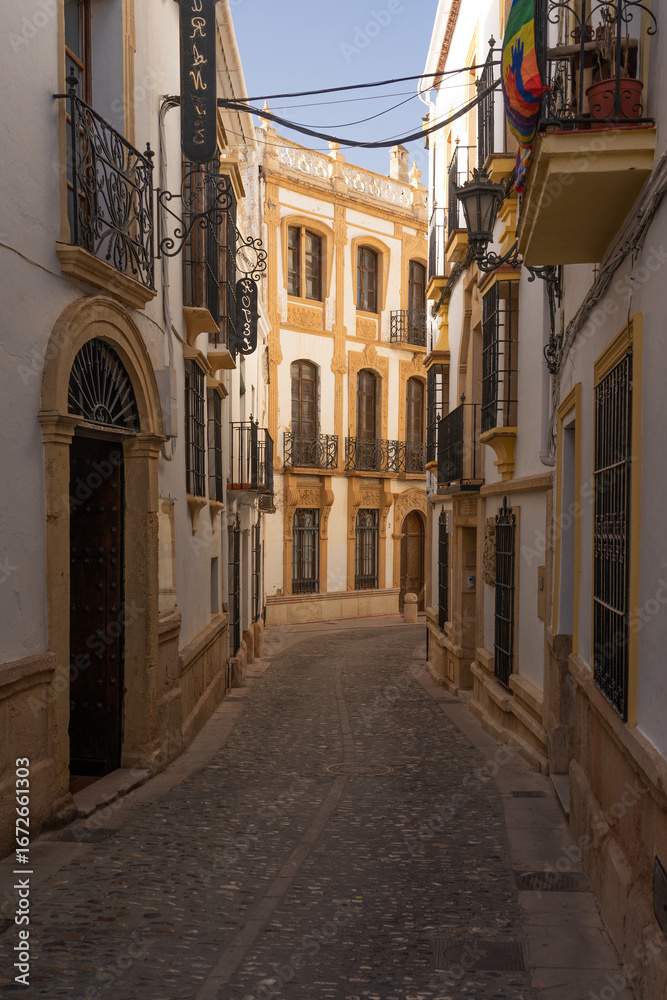 Fototapeta premium Beautiful street in the old town of the city of Ronda at sunset. Malaga, Andalucia, Spain.