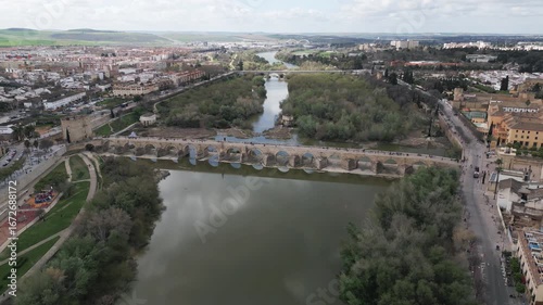 Aerial footage showcase a vintage Roman bridge spanning the the Guadalquivir River in historic town of Cordoba, Andalusia, Spain	
