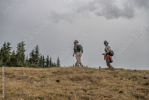 two people walking on a hill hiking