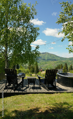 Two chairs and jacuzzi on patio with mountain view in Ukraine