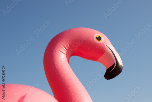 Close-up of an inflatable pink flamingo against a blue sky