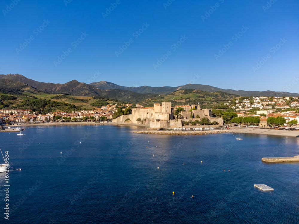 Fototapeta premium View on sea with beaches and colourful houses of Collioure, Cote Vermeille, Pyrenees-Orientales, Occitania, France. Summer vacation destination, blue sea water and hilly landscape