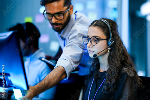 фотографія A diverse team of technical support specialists works a late shift in a busy call center