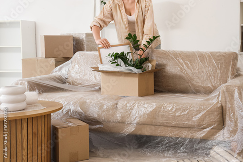 Young woman packing box in ...