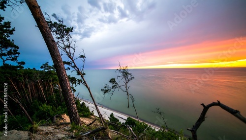 Fototapeta Naklejka Na Ścianę i Meble -  Scenic coastal landscape featuring dramatic sunset over the Baltic Sea waters