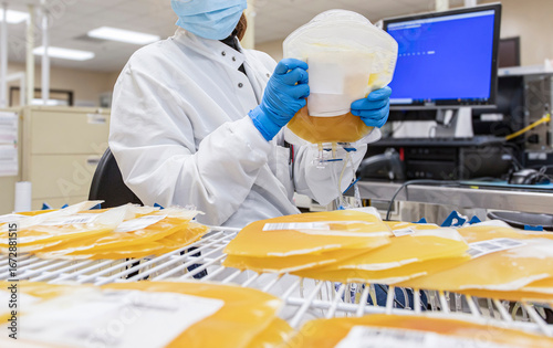 Fotografía A lab worker handling bags of human plasma