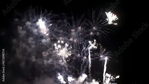Brilliant fireworks display explodes across the night sky, illuminating the darkness with dazzling light trails and sparks.