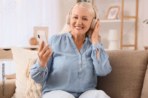 Senior woman in headphones ...