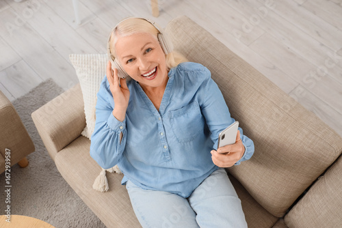 Senior woman in headphones ...