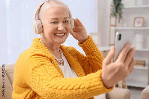 Senior woman in headphones ...