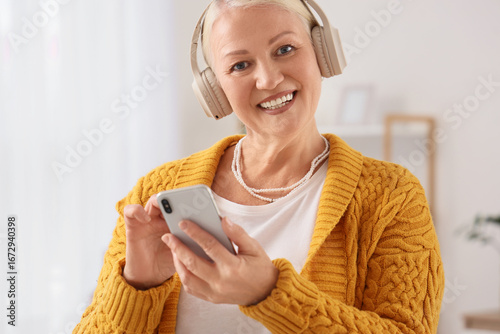 Senior woman in headphones ...