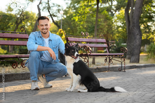 Young man with Border Collie dog in park