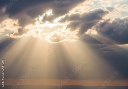 Dramatic golden sun rays pierce through dark, stormy clouds, casting beautiful light over the distant horizon at dusk