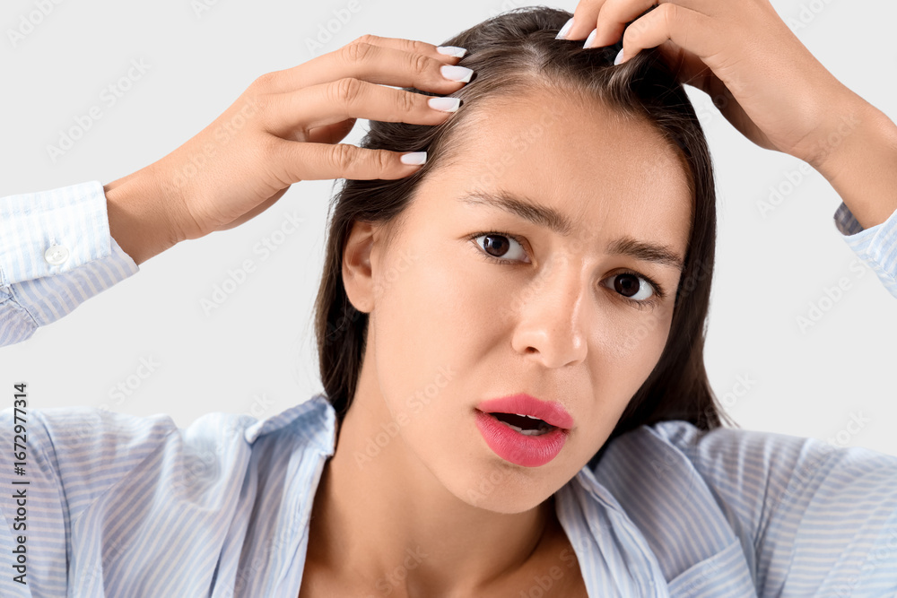 Naklejka premium Worried young woman with hair loss problem on light background, closeup