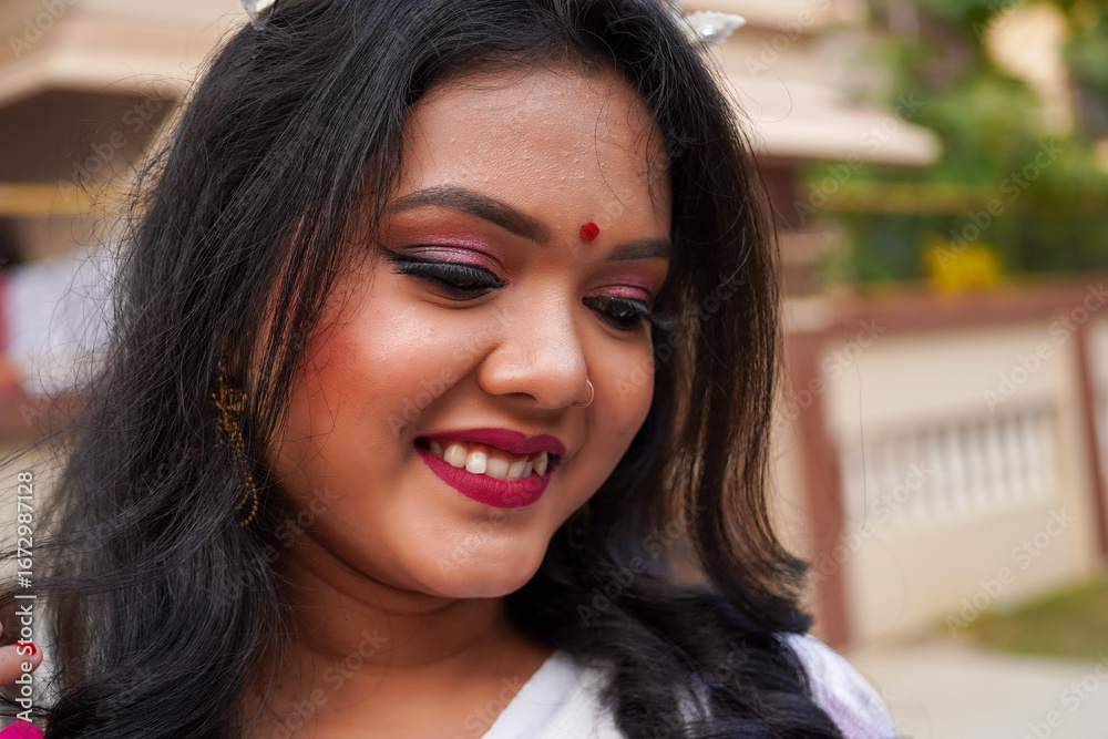 Obraz premium Stunning Indian bride during make up in Hindu traditional wedding clothes Saree and golden jewelry in a make up studio. Bengali wedding. Kolkata wedding. Indian model bridal shoot. Indian wedding.