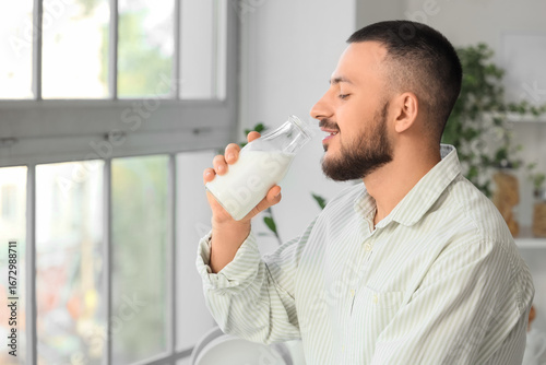 Young man drinking tasty mi...