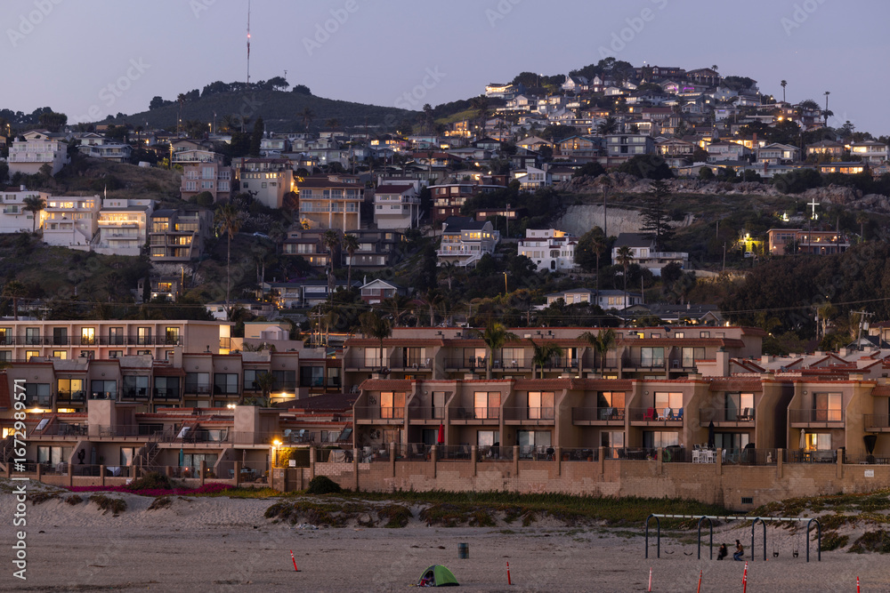 Obraz premium Twilight view of housing and buildings along the hilly coast of Pismo Beach, California, USA.