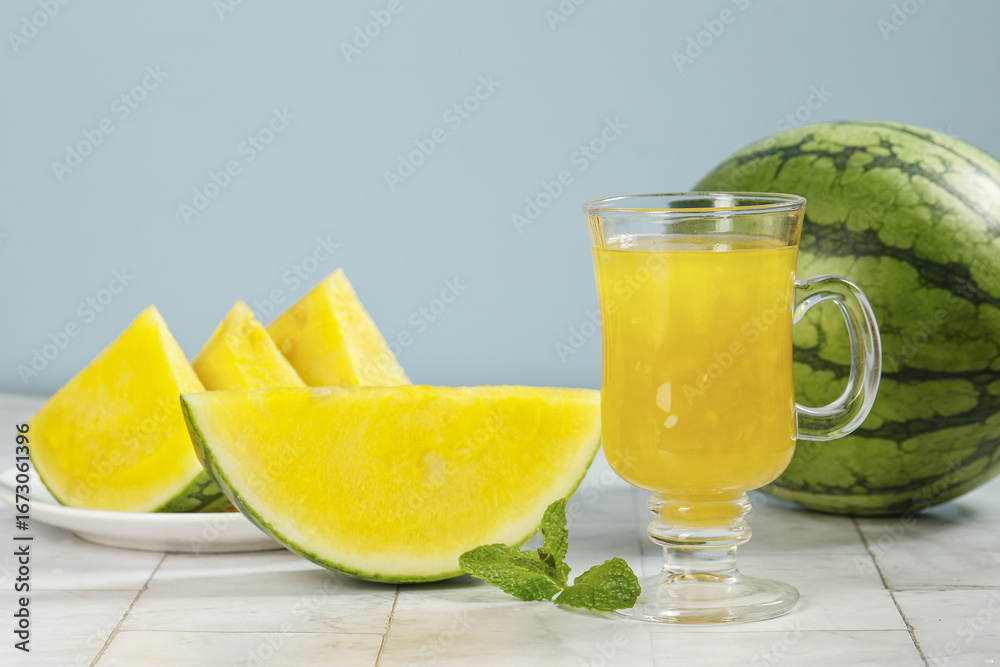 Fototapeta premium Fresh Yellow Watermelon Slices and Juice with Mint on White Wood Background