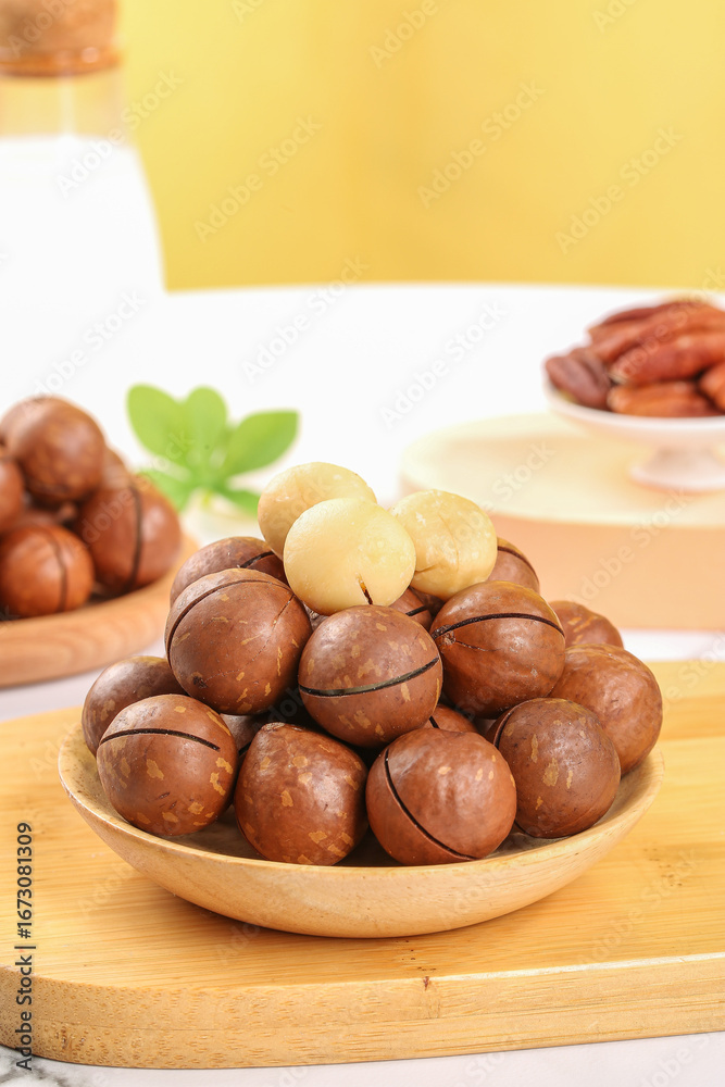 Obraz premium Macadamia Nuts in Wooden Bowl with Creamy Butter on Kitchen Cutting Board