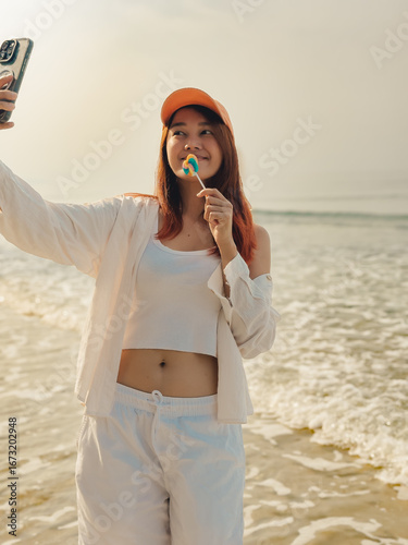Happy woman enjoy taking selfie photo on the beach in Thailand.