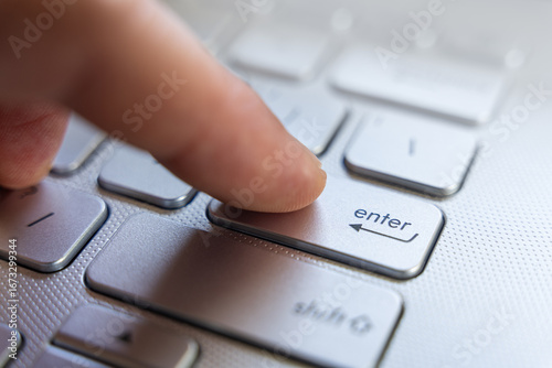 Obraz na plátně Finger Pressing Enter Key On Laptop Keyboard Close Up