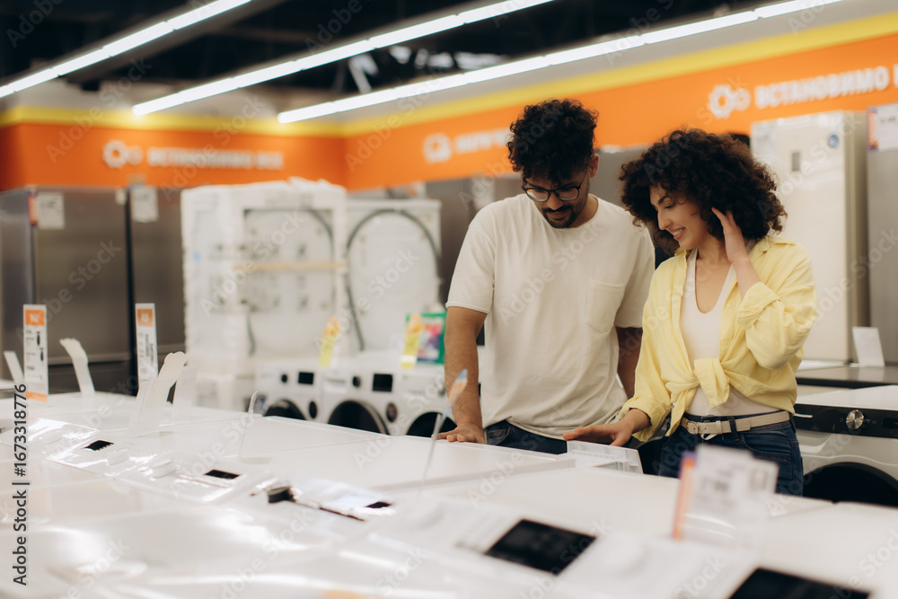 Fototapeta premium Couple Exploring Latest Home Appliances in Modern Electronics Store