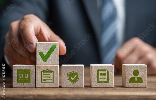 Hand placing a wooden block with a checkmark on top of a stack of blocks with various business icons