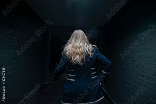 Fototapeta Blonde woman in dark underground tunnel creating dramatic atmospheric portrait l