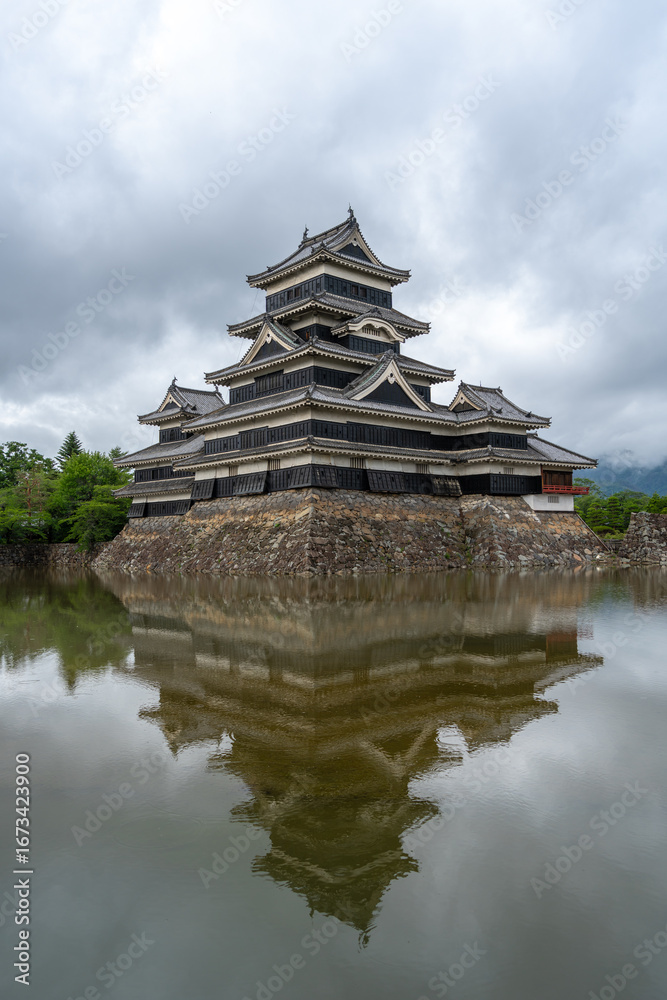 Fototapeta premium Historic Matsumoto Castle reflected in calm waters, Japan