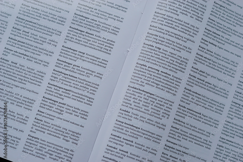 Obraz premium A close-up of an open medical textbook, showing detailed text and diagrams about human physiology and biology. This image represents study, education, research, and the journey of a medical student.
