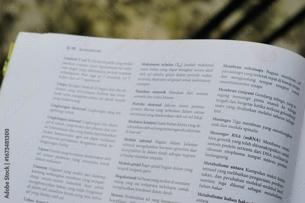 Obraz premium A close-up of an open medical textbook, showing detailed text and diagrams about human physiology and biology. This image represents study, education, research, and the journey of a medical student.