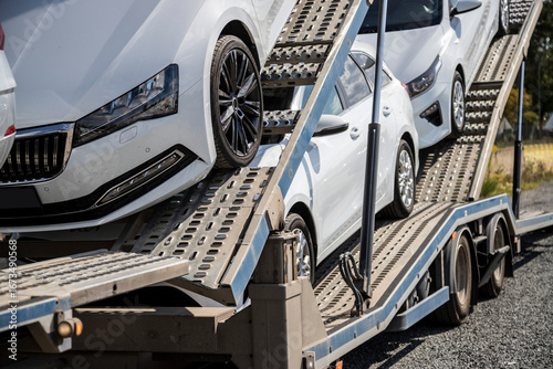 Fotografie Pre-owned white cars, sedan and wagons, on car carrier trailer, car-carrying trailer, car hauler, auto transport trailer, semi-trailer