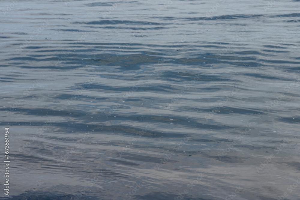 Naklejka premium Langrune-Sur-Mer, France - 08 07 2025: Sea background. Detail view of a dark blue water in the sea