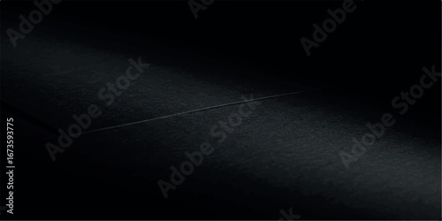 A subtle line of light cuts across a dark, textured surface, revealing a faint crease or seam in the abstract composition