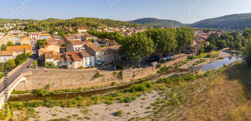 Panorama of Bize-Minervois and the river Cesse, in Occitanie, France, with typical southern french houses in beige and terracotta colors, early summer morning