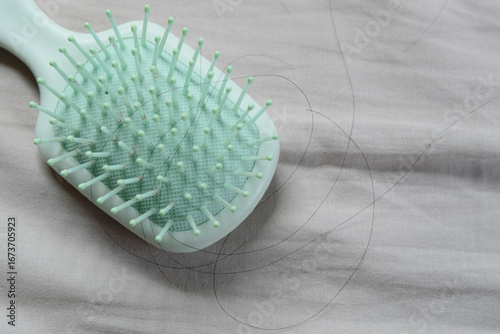 Fallen hair on a cloth with a hairbrush, showing the hair loss problem.