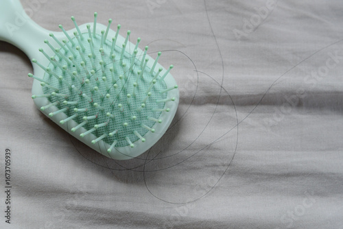Fallen hair on a cloth with a hairbrush, showing the hair loss problem.