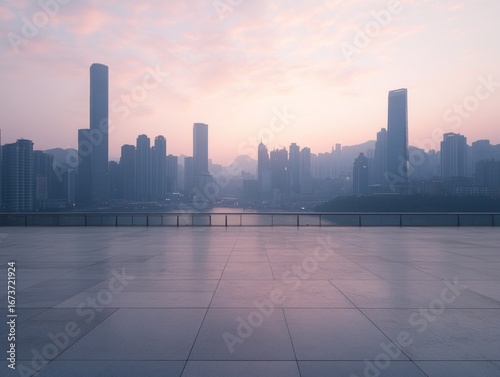 Empty plaza overlooking city skyline at sunrise