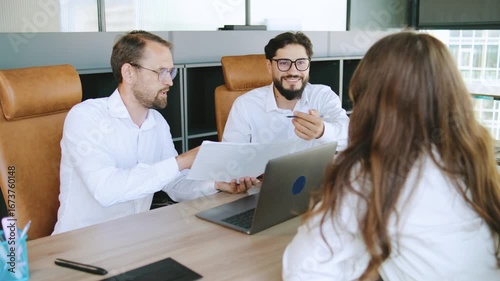 Team members discuss project details in a modern office setting during a business meeting focused on collaboration and strategic planning